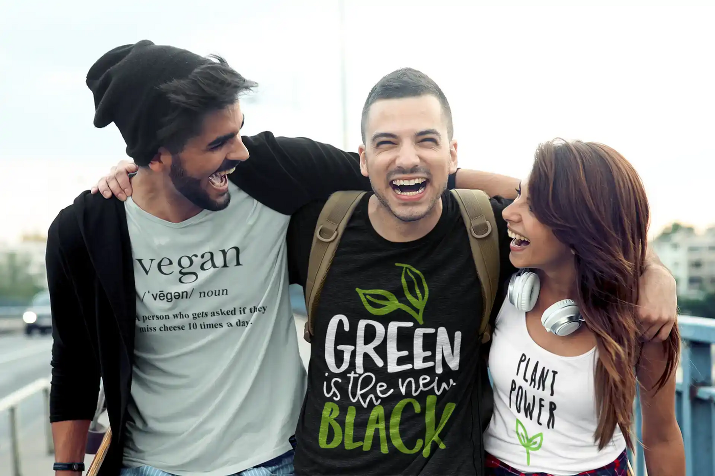 Three smiling friends wearing vegan-themed shirts.